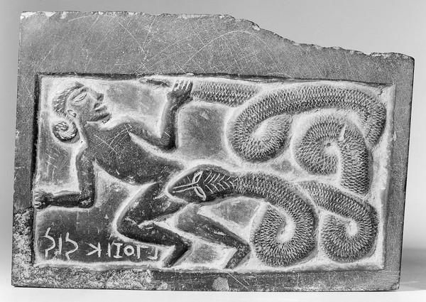 Plaque carved in relief showing a man and snake. Inscription, does not appear to be Greek. Probably reversed as for making and impression.