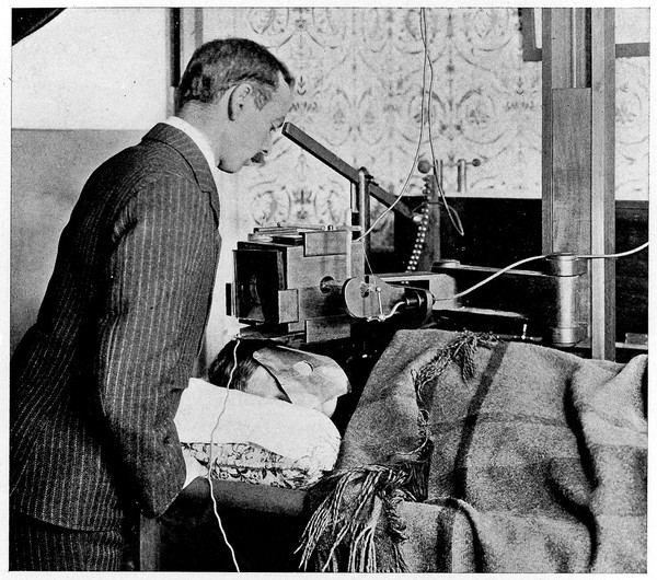 M0015493: X-ray therapy in 1902: the patient on a couch and a shield round the tube - an unusual precaution at that time