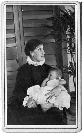 Mrs. T.R. Lewis seated with baby.