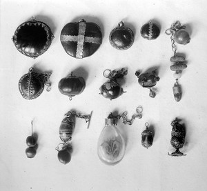 view Spanish amulets; vegetable products. Entada seeds; mucuna seeds; horse-chestnuts; pair of date stones with stone beads and tooth; 2 hazlenuts (formerly 3); hazlenut; bottle containing flowers; 2 nuts.