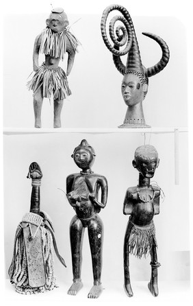 Five African statues, effegies including, top right, an anthropomorphic face surrounded by three horn-like structures, Ekoi [?], Nigeria