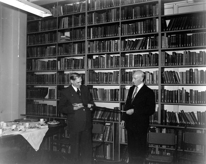 The Wellcome Historical Medical Museum, 28 Portman Square, London: the Director presenting an umbrella to A. D. Lacaille, the museum's archaeologist, on his retirement in 1959. Photograph.