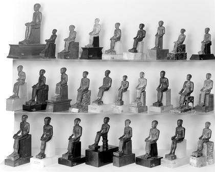 Collection of figures of Imhotep, Egyptian. Group I, front view. L. to R. R41, 73, 74, 64, 61, 3726, 76, 2948, 52/1936 middle row R4190/37, 79, 2943, 44, 48, 56/1936, R28479, 51, 65, 43/1936 bottom row R47, 53, 77/1936, A190368, 12340, 45, 40, 459/1936