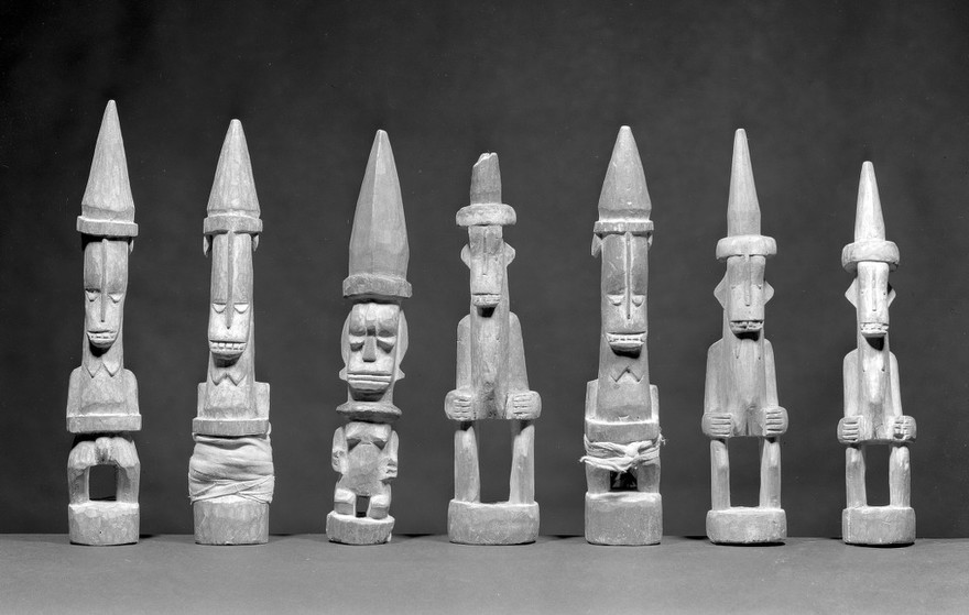 M0019325EA: Seven carved wood statues representing Oma, a household god: front view