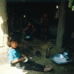 view Nepal; child eating rice, Terai, 1986