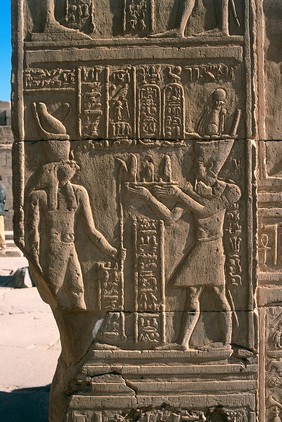 Ptolemaic pharaoh offering gifts to Horus, wall relief