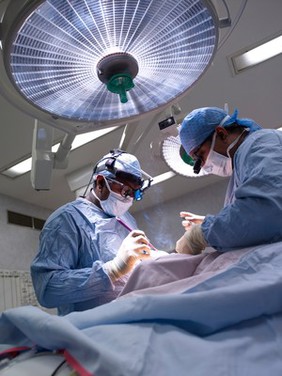 Two male surgeons operating on a patient.