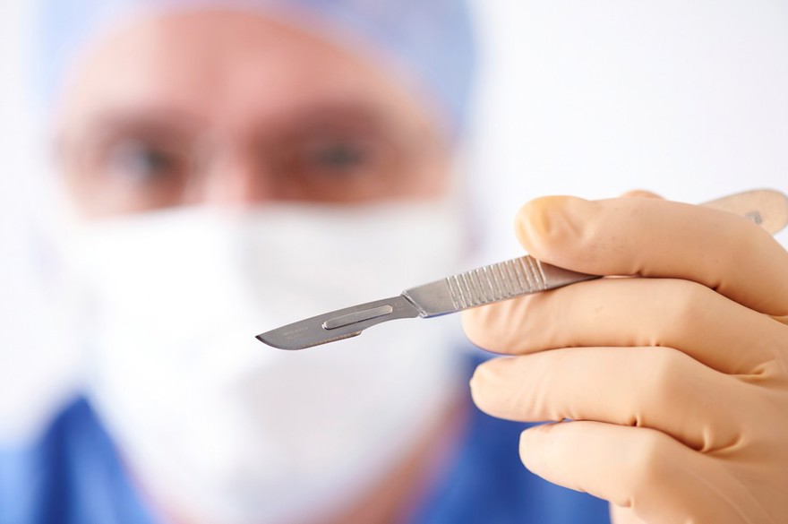 White male surgeon with scalpel