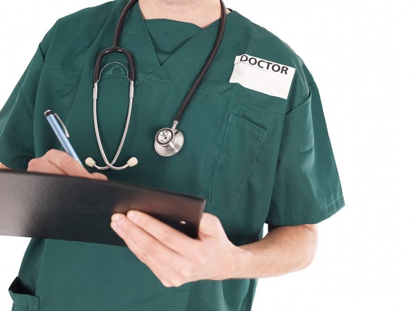 Doctor in scrubs making notes