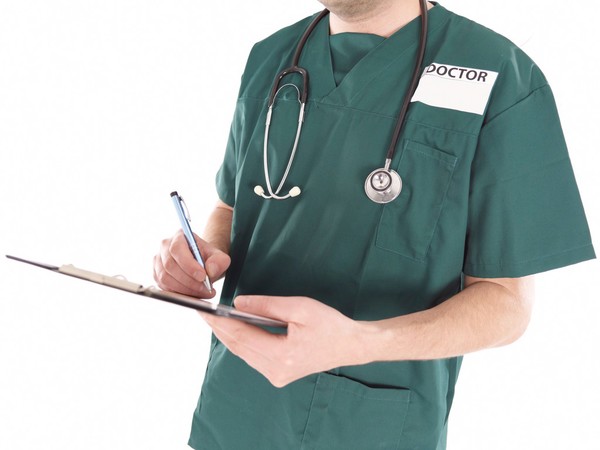 Doctor in scrubs making notes