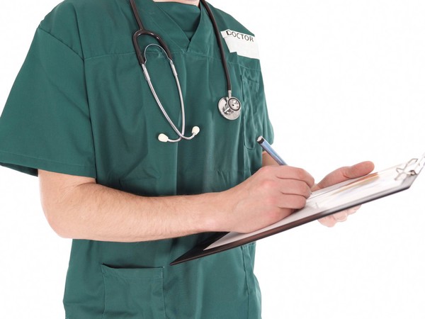 Doctor in scrubs making notes