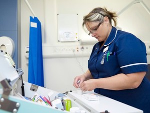 view Nurse during a drug administration on a UK hospital ward