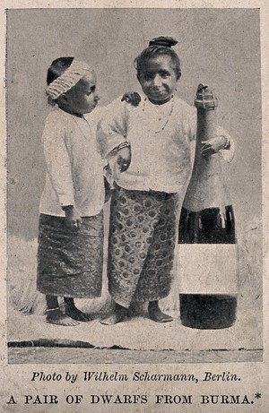 view Two dwarfs from Burma, standing next to a bottle. Reproduction of a photograph after W. Scharmann.