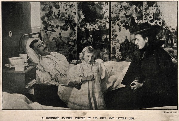 Boer War: a wounded soldier being visited in hospital by his wife and little daughter. Halftone, c. 1900, after a photograph by E. H. Mills.