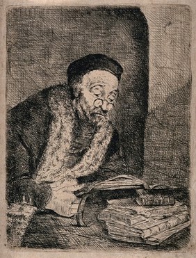 An old man wearing spectacles sits at a table reading. Etching.