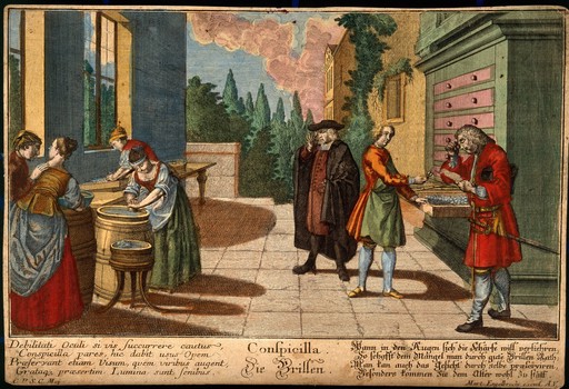 Women grind glass lenses while two customers try spectacles on. Coloured line engraving, 1799?.