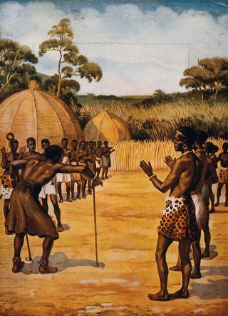 A Swazi medicine man or shaman performing a ritual in front of his tribe. Colour process print after N.H. Hardy.