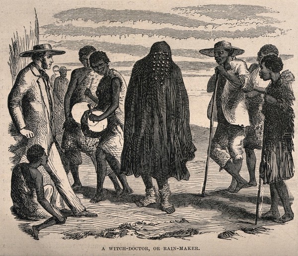 An African shaman and rain-maker in his/her ritual costume. Wood engraving.