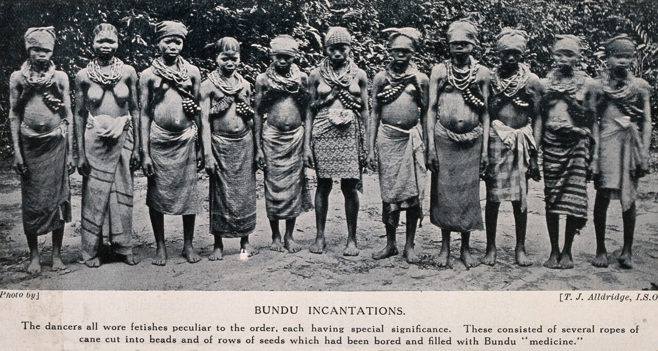 A group of Bundu female dancers all wearing necklaces of beads which are filled with medicines. Halftone after a photograph by T.J. Alldridge., by T. J. Alldridge