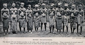 view A group of Bundu female dancers all wearing necklaces of beads which are filled with medicines. Halftone after a photograph by T.J. Alldridge.