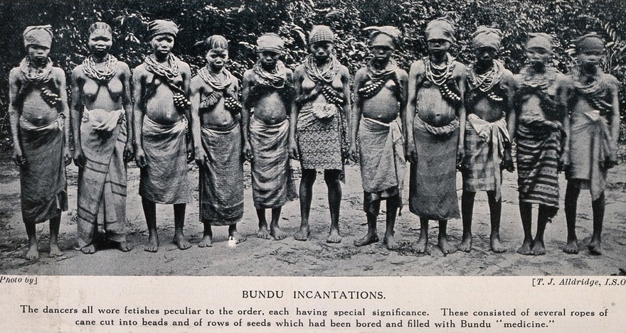 A group of Bundu female dancers all wearing necklaces of beads which are filled with medicines. Halftone after a photograph by T.J. Alldridge.