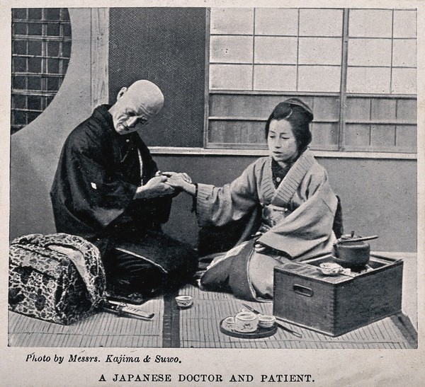 A Japanese doctor taking the pulse of a patient. Halftone after a photograph by Messrs. Kajima & Suwo.