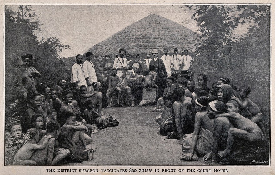 A white doctor vaccinating a African child, surrounded by crowds of women and children waiting to be vaccinated. Process print by Meisenbach after a photograph.