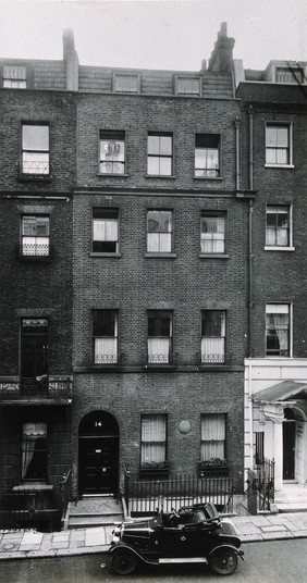 Facade of 14 Hertford Street, Mayfair, where Edward Jenner first practiced in London in 1808; car in the foreground. Photograph, 1930/1937?.