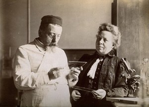 view Professor and Mrs Dejerine looking at a microscopic sample of the human brain. Photograph.