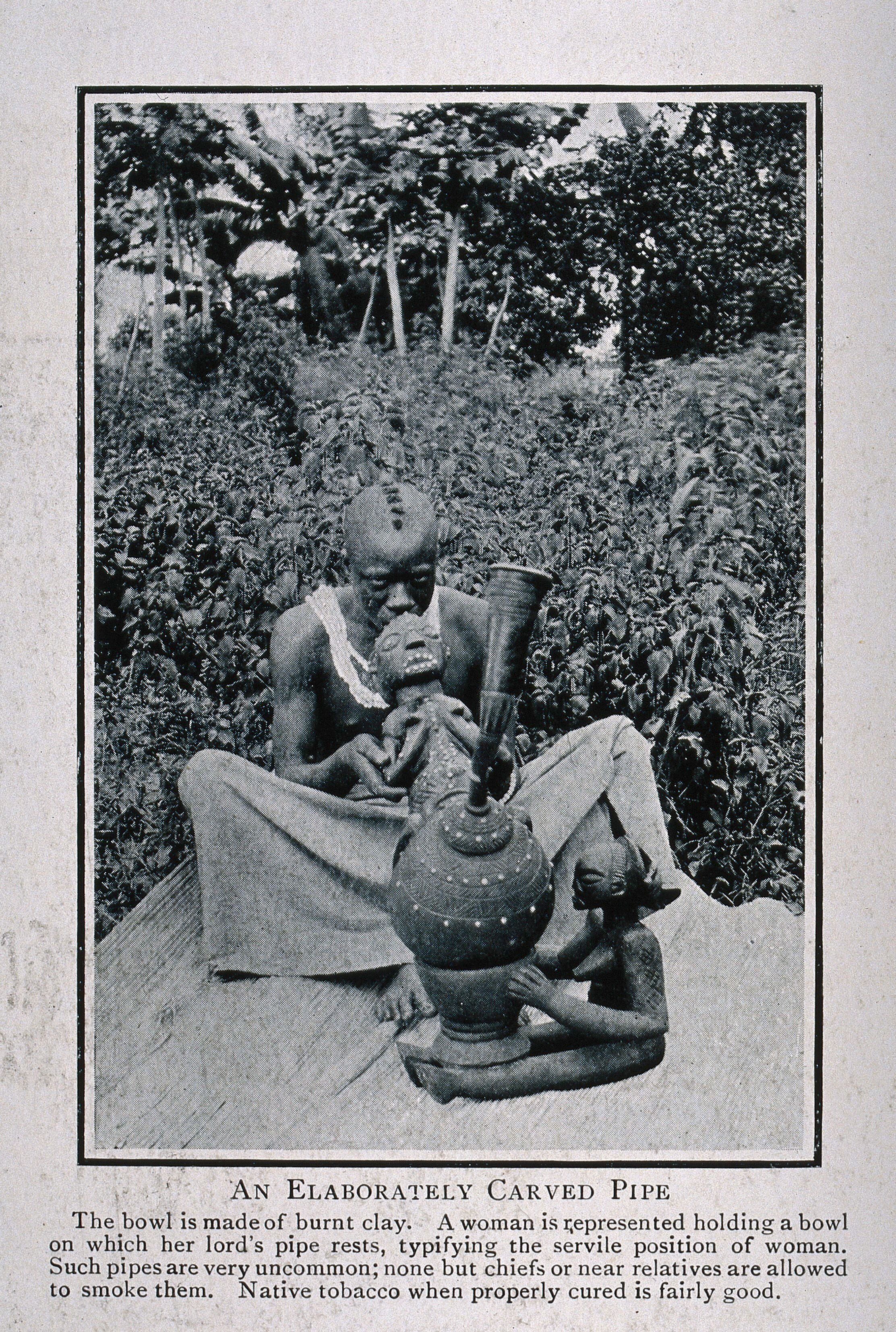 An African Chief Smoking A Very Elaborately Carved Tobacco Pipe