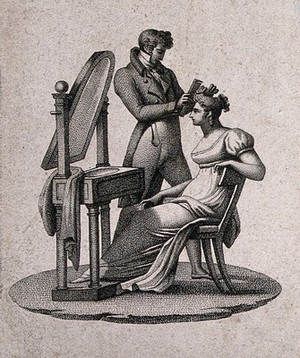 view A woman sitting at her dressing table having her hair combed by a male hair-dresser. Stipple engraving.