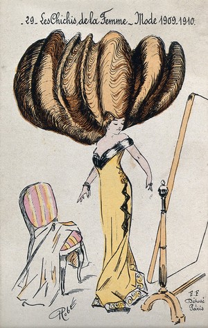 view A woman with her hair dressed in an enormously high chignon looking at herself in a full-length mirror. Coloured line block by Robé (?).
