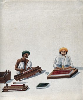 Two Indian bookbinders: one trimming page edges in a press, the other decorating a binding. Watercolour.