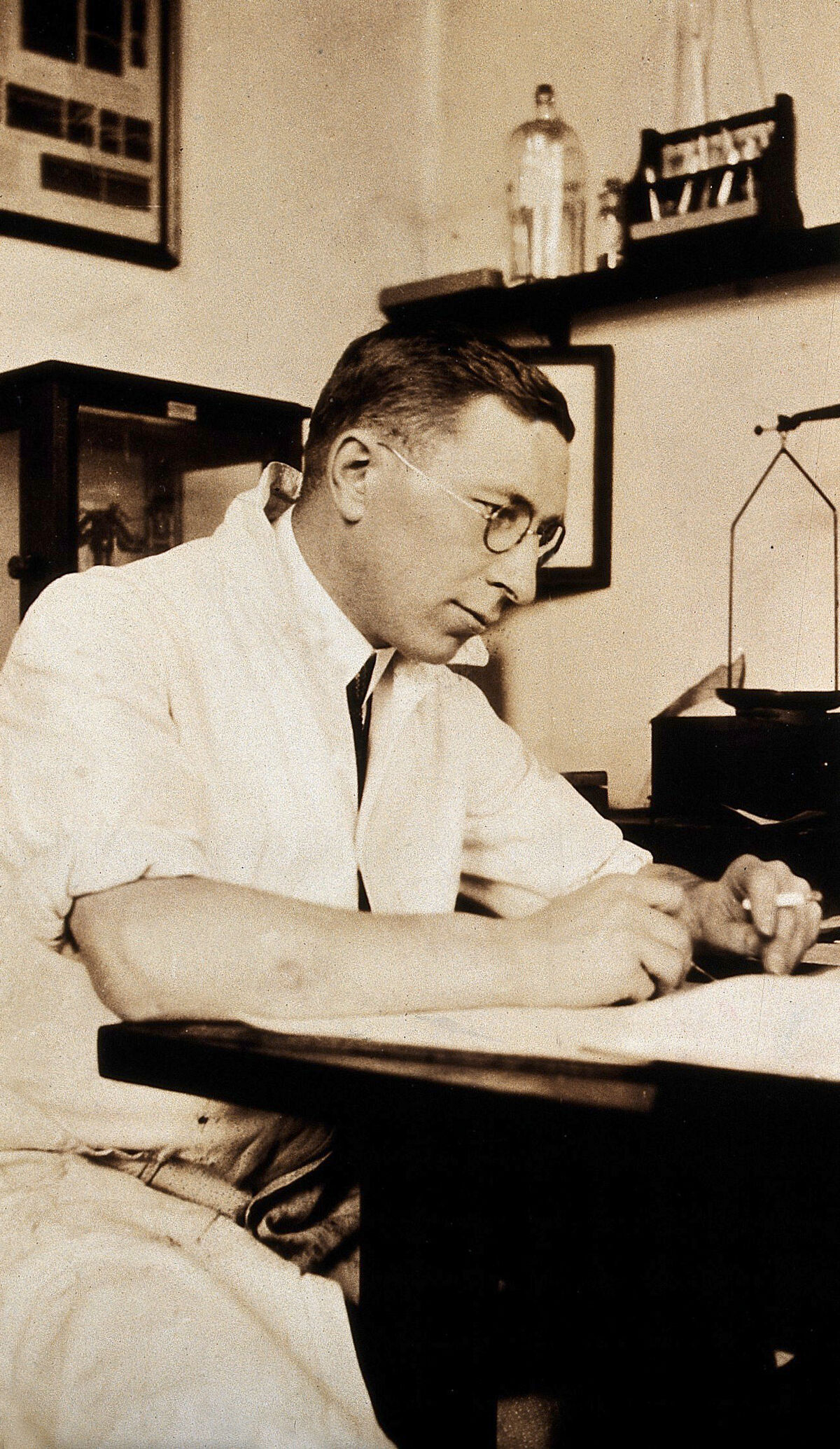 Fotografia histórica de Frederick Banting escrevendo à escrivaninha de seu laboratório