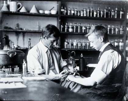 Louis Cobbett injecting a hamster with anti-toxin in the Pathology Department of Cambridge University, assisted by Alfred Clark. Copy photograph, ca. 1960 after the original photograph, ca. 1905 (?).