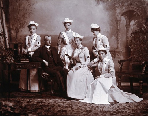 A doctor with five nurses: studio portrait. Photograph, ca.