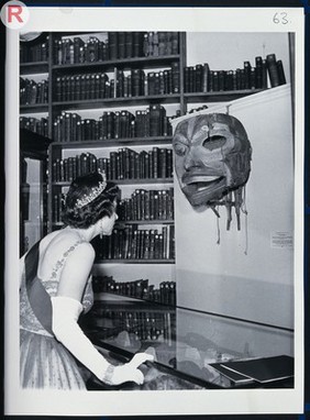 HM Queen Elizabeth II looking at a Ceylonese mask. Photograph by the Associated Press Ltd., 1962.