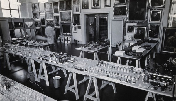 The Wellcome Research Institution building, Euston Road, London: south west corner of the former Hall of Statuary, with a display of paintings and glassware. Photograph, 19--.