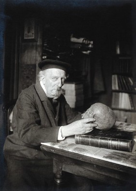 Adrien de Mortillet, holding a skull. Photograph.