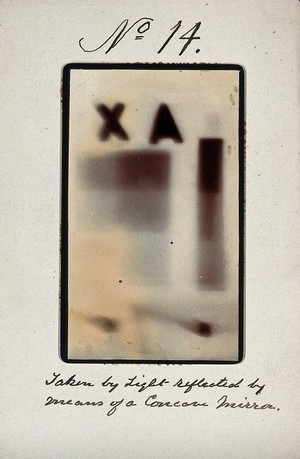 view Light emitted by Röntgen Ray Tubes, reflected using a concave mirror: blurred letters and shapes. Photoprint from radiograph, by James Wimshurst, 1898.