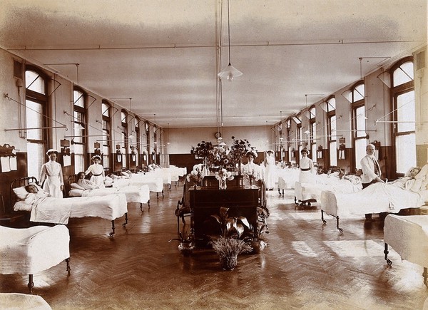 Great Northern Central Hospital, Holloway Road, London: a hospital ward with patients and staff. Photograph, 1912.