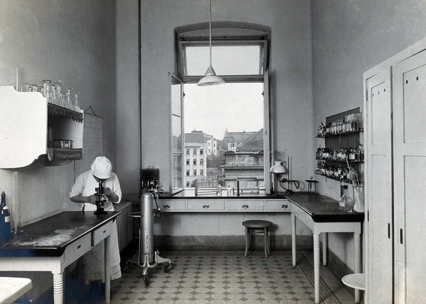 University Children's Hospital, Vienna: a nurse looking through a microscope. Photograph, 1921.
