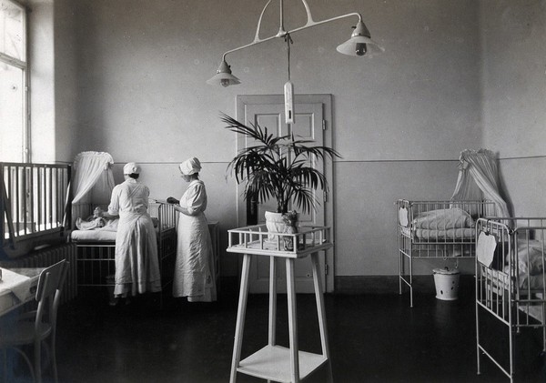 University Children's Hospital, Vienna: nurses attending to a baby in the maternity ward. Photograph, 1921.