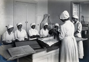 view University Children's Hospital, Vienna: a nurse making a demonstration to other nurses with a newborn baby. Photograph, 1921.