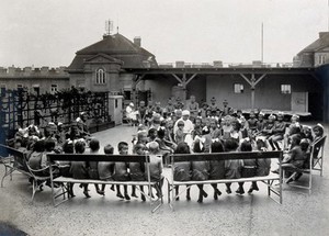 view University Children's Hospital, Vienna: children in the roof garden being read to by a nurse. Photograph, 1921.