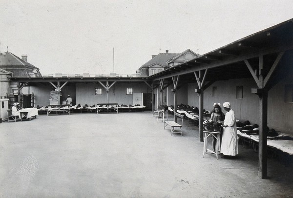 University Children's Hospital, Vienna: children lying flat on their beds around the edges of the roof garden. Photograph, 1921.