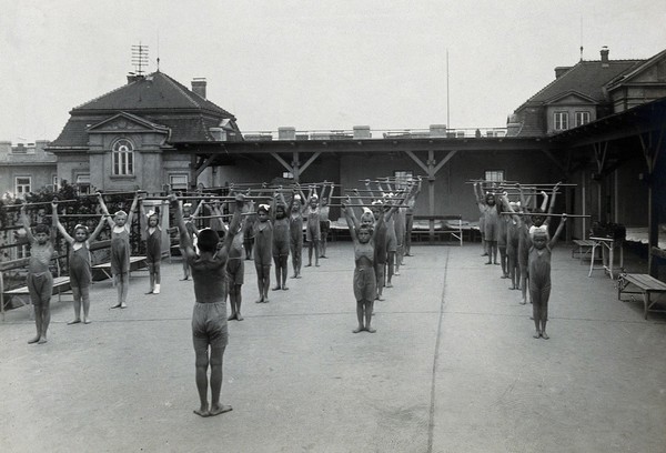 University Children's Hospital, Vienna: children exercising with wooden batons, on the roof garden. Photograph, 1921.