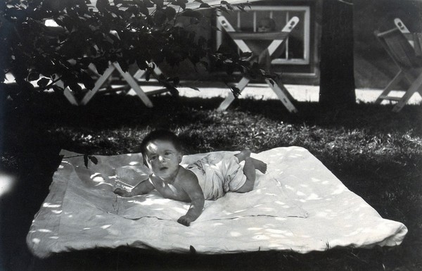 University Children's Hospital, Vienna: a baby from the Escherich section on a blanket outdoors. Photograph, 1921.