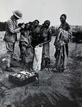 A medical officer taking a sample of blood from an inhabitant of Buruma Island, suffering from sleeping sickness. Photograph, 1965, after photograph 1902.