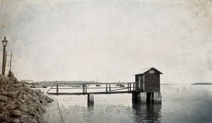 view Wooden building on a river; to be used as a public toilet in Bonthe, Sierra Leone. Photograph, c. 1911.